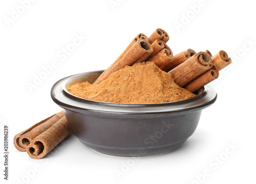 Bowl with aromatic cinnamon sticks and powder on white background