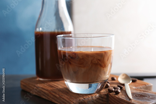 Glass with cold brew coffee and milk on wooden board