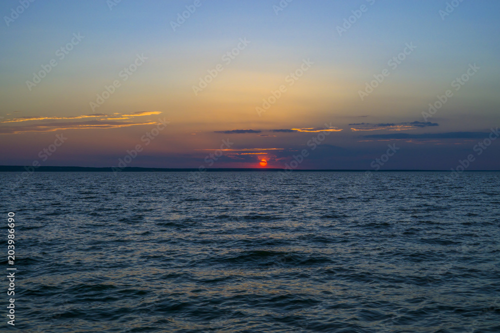 Colorful sunset with blue cloudy sky above sea. Relaxation landscape
