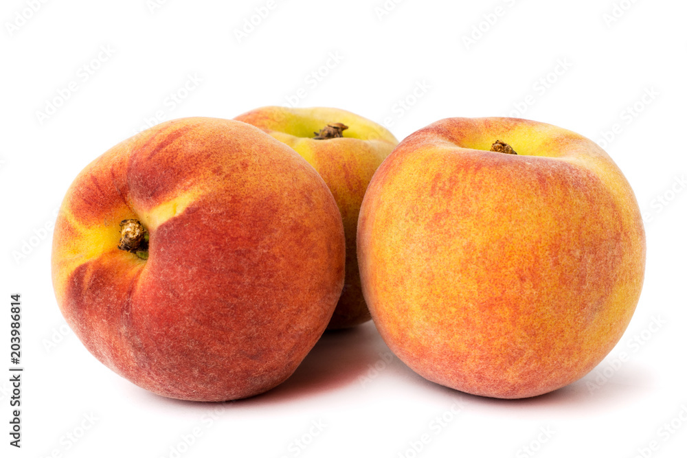 Three ripe peaches with natural shadow on a white, closeup. Three ripe peaches with natural shadow on a white, closeup.