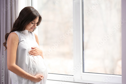 Beautiful pregnant woman near window at home Free Download Beautiful pregnant woman near window at home - GFXLoad