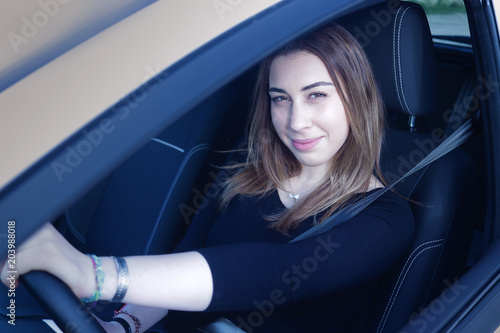 Beautiful girl driving a new car just after the driver licence exam.