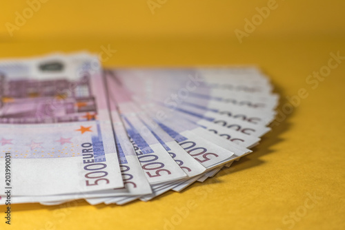 Many euro bills closeup on yellow background