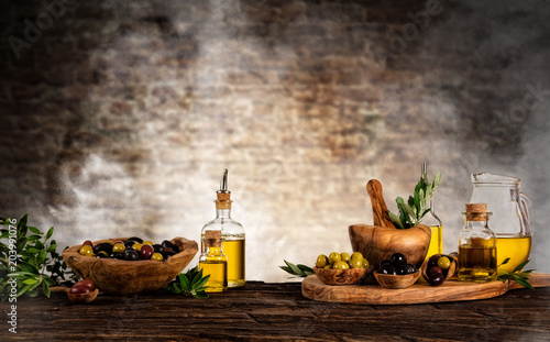 Fresh harvested olives with oil, placed on wooden table