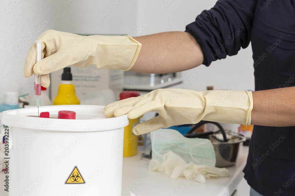 Obraz premium leaving a used syringe in the bucket marked for biological risk