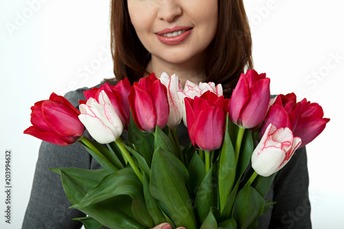 Mothers Day Beautiful woman with flowers tulips in hands on white background. Mother's Day concept.