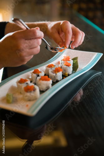 Japanese chef preparing sushi rolls on a long dish. sushi concept