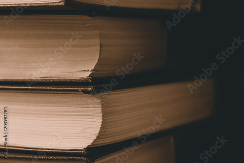 Close-up vertical stack of books background toned