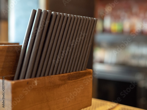 Container filled with paper straws at a bar photo