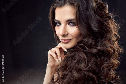 Portrait of a young attractive woman with gorgeous curly hair. Attractive brunette photo