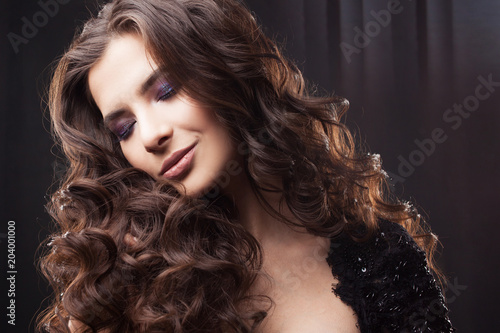 Portrait of a young attractive woman with gorgeous curly hair. Attractive brunette