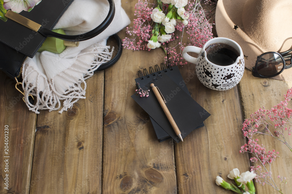Black fragrant coffee, flowers, hat, bag and glasses. Good morning, bright sunny colors. Women's accessories and notepad with a pen. Planning the day