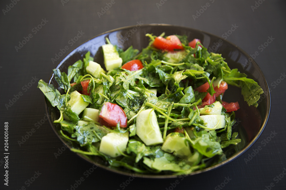 Summer salad with fresh vegetables and greens in a bowl. Closeup. Summer salad with fresh vegetables and greens in a bowl. Closeup.