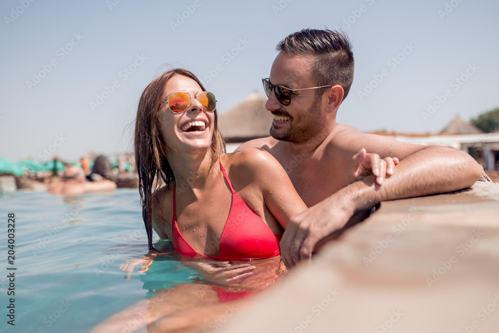 Young couple in the swimming pool enjoying together Young couple in the swimming pool enjoying together