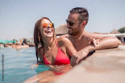 Young couple in the swimming pool enjoying together