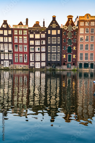 View of typical colorful Dutch houses in Amsterdam reflecting in the Amstel river canal