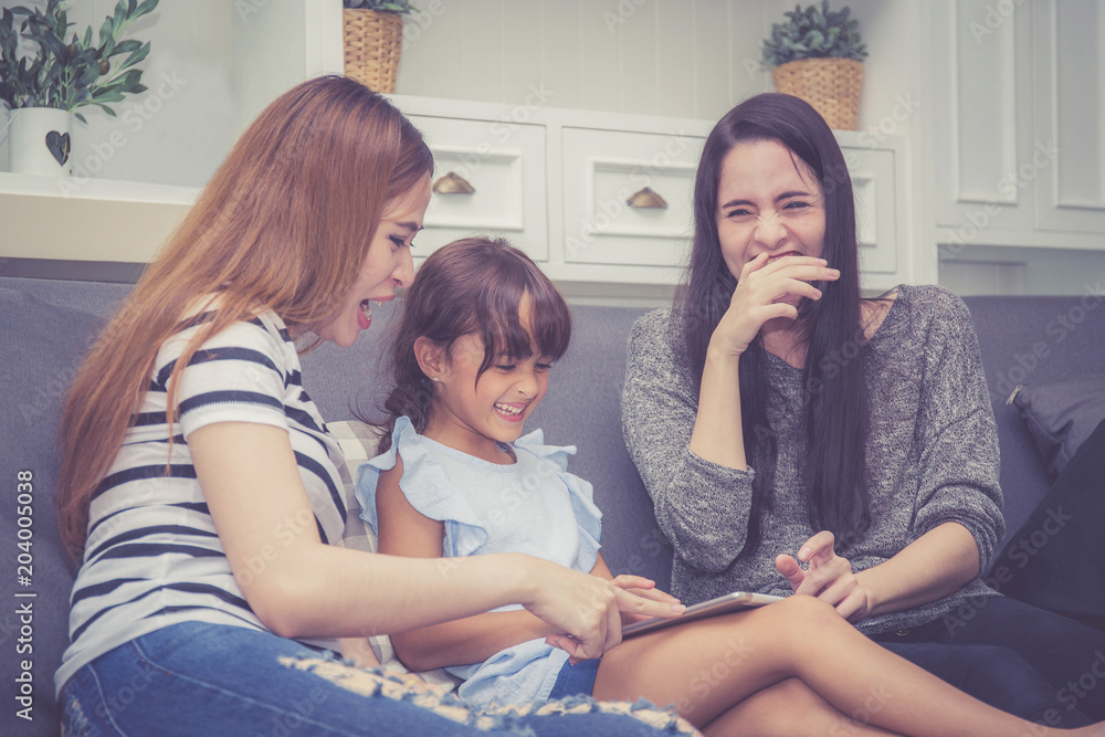 Mother, Aunt and kid having time together lerning with using tablet at home with relax and happy on couch, education and lifestyle concept. Mother, Aunt and kid having time together lerning with using tablet at home with relax and happy on couch, education and lifestyle concept.