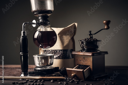 Japanese siphon coffee maker and coffee grinder on old kitchen table
