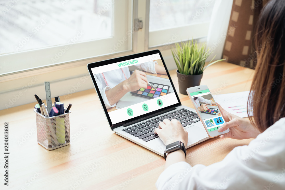 Fototapeta premium Businesswoman in office in casual shirt. Use computer for graphic designer and choose a color sample to match the publication.