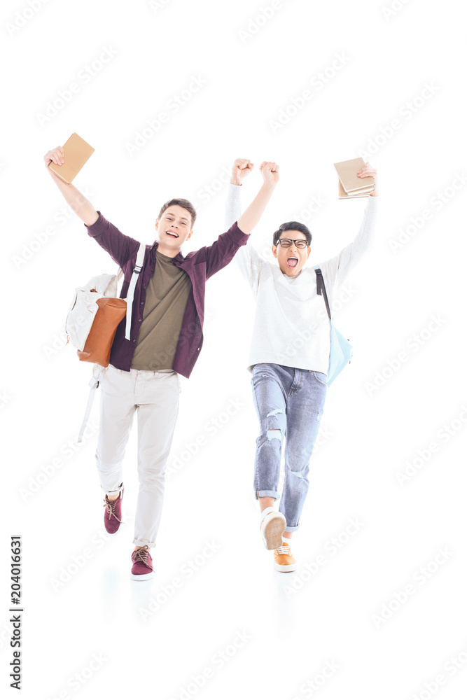Obraz premium happy multiethnic students with backpacks and books isolated on white