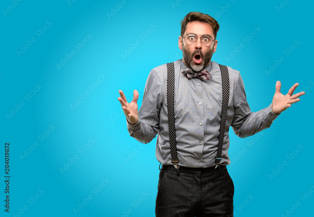 Middle age man, with beard and bow tie happy and surprised cheering expressing wow gesture Middle age man, with beard and bow tie happy and surprised cheering expressing wow gesture