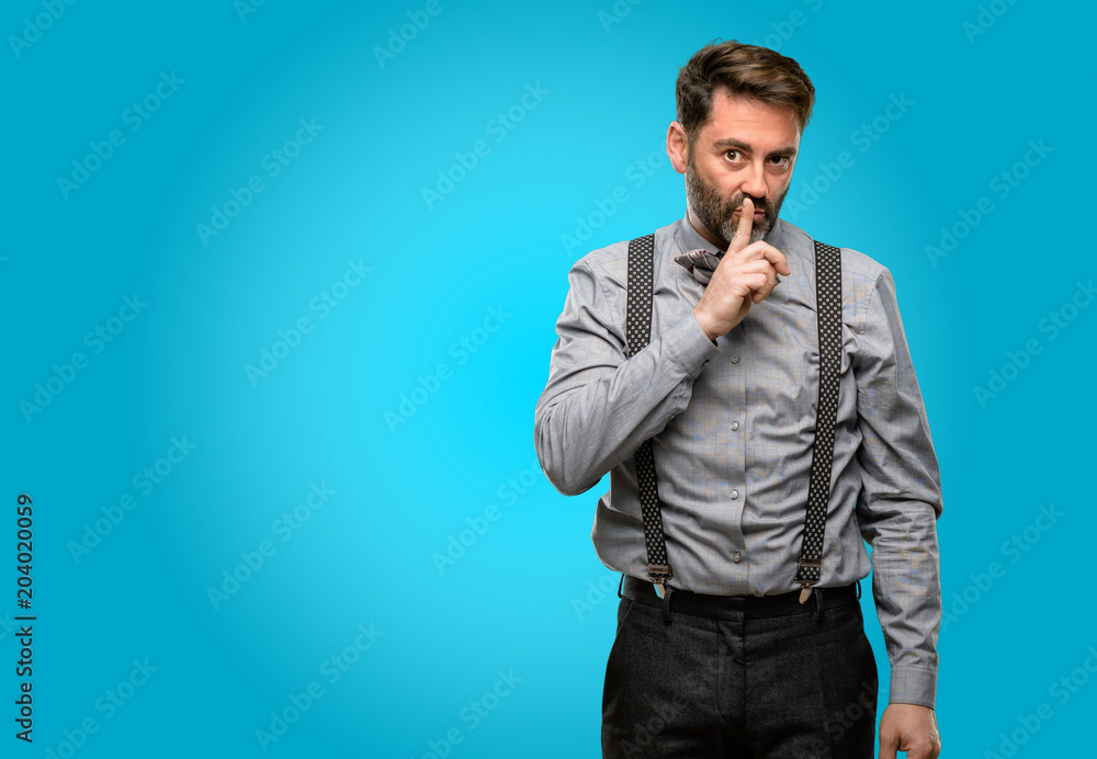 Middle age man, with beard and bow tie with index finger on lips, ask to be quiet. Silence and secret concept Middle age man, with beard and bow tie with index finger on lips, ask to be quiet. Silence and secret concept