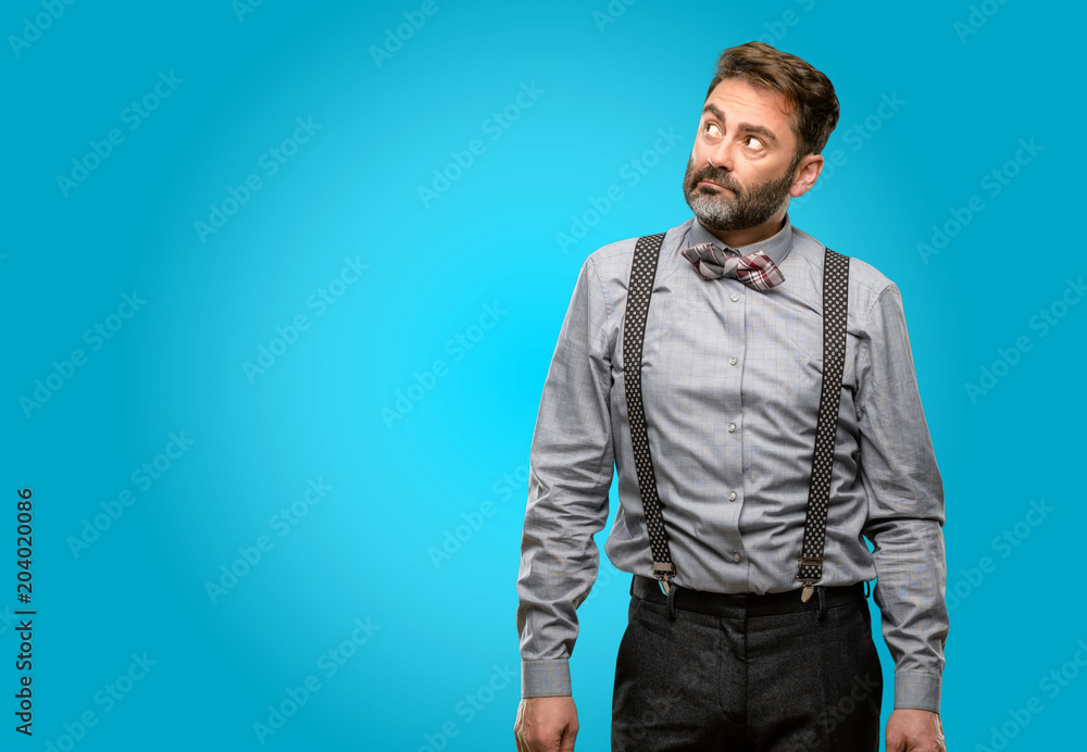 Middle age man, with beard and bow tie doubt expression, confuse and wonder concept, uncertain future Middle age man, with beard and bow tie doubt expression, confuse and wonder concept, uncertain future