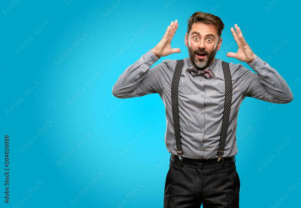 Middle age man, with beard and bow tie happy and surprised cheering expressing wow gesture Middle age man, with beard and bow tie happy and surprised cheering expressing wow gesture