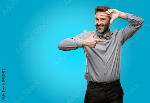 Middle age man, with beard and bow tie confident and happy showing hands to camera, composing and framing gesture