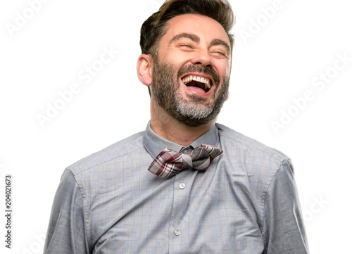 Middle age man, with beard and bow tie confident and happy with a big natural smile laughing isolated over white background © Krakenimages.com