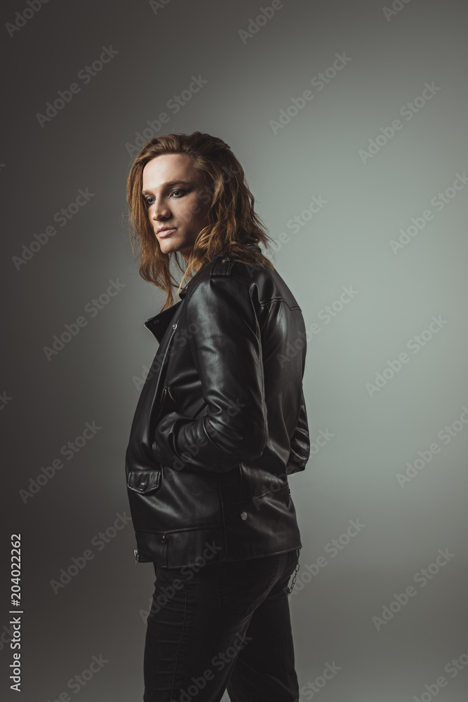 Fototapeta premium rock man posing in black leather jacket, isolated on grey