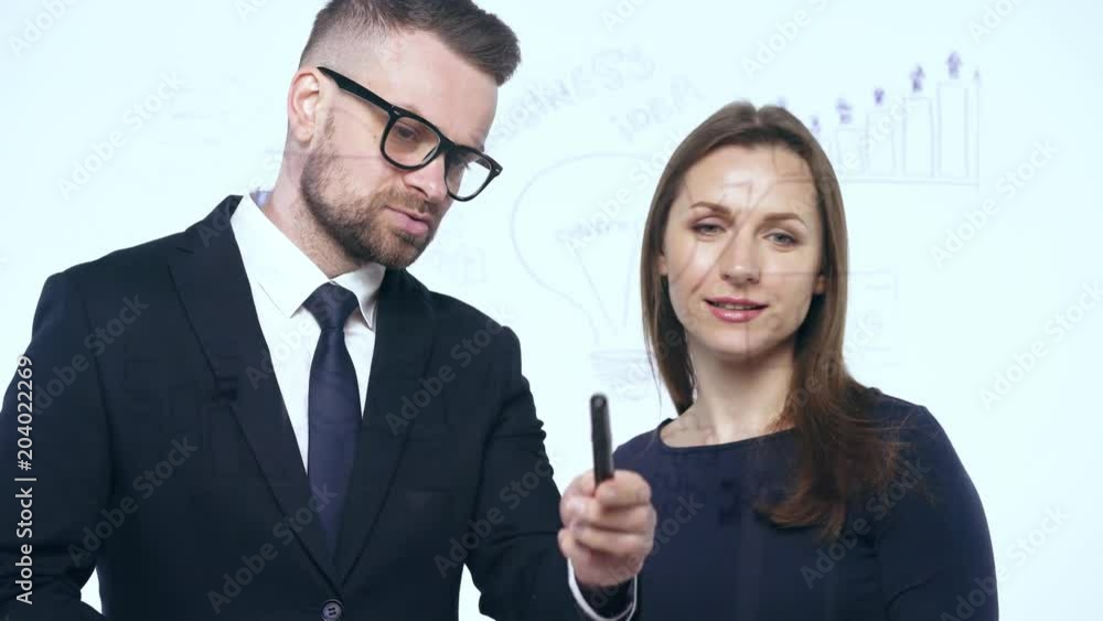 Man and woman shake hands and discuss the business strategy for success in a modern glass office Man and woman shake hands and discuss the business strategy for success in a modern glass office