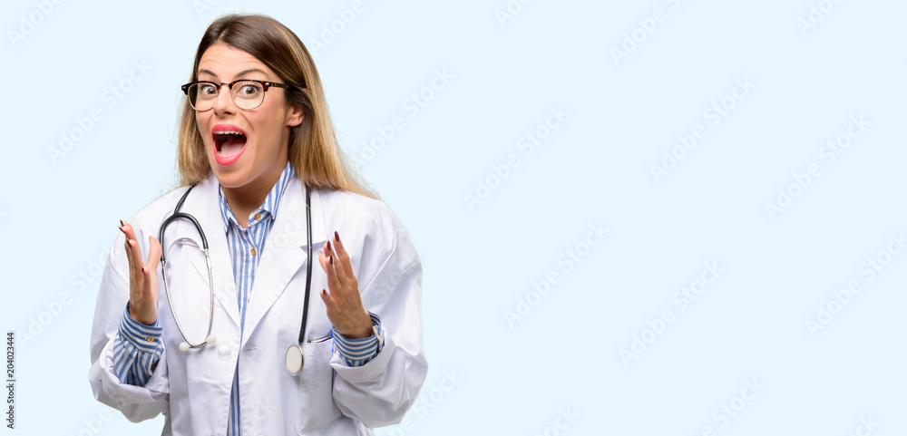 Young doctor woman, medical professional stressful keeping hands on head, terrified in panic, shouting Young doctor woman, medical professional stressful keeping hands on head, terrified in panic, shouting