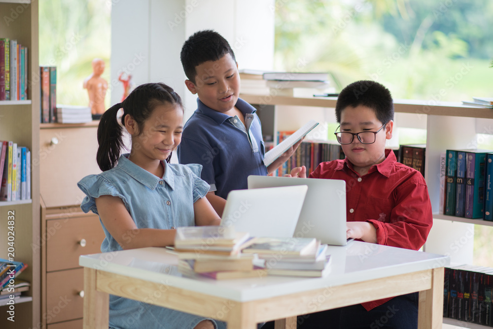 Students boy and girl in the library read books and ebook for education Students boy and girl in the library read books and ebook for education