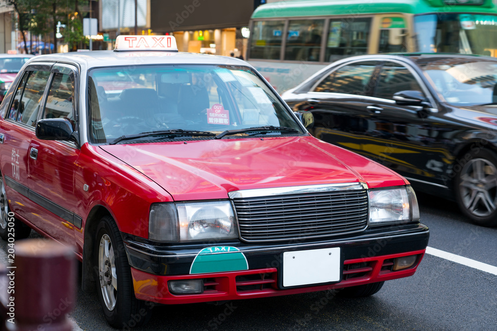 Details of red taxi cars out of service on the street with chinese language. A Hong Kong taxi is out of service in city downtown.