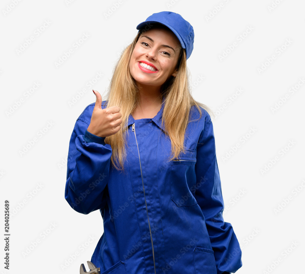Young plumber woman smiling broadly showing thumbs up gesture to camera, expression of like and approval Young plumber woman smiling broadly showing thumbs up gesture to camera, expression of like and approval