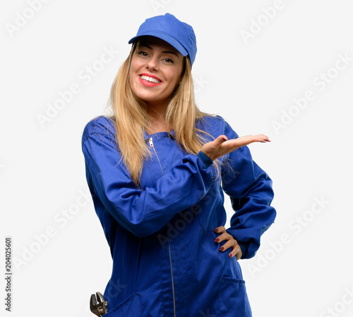 Young plumber woman holding something in empty hand