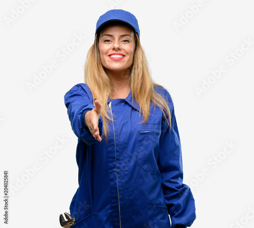 Young plumber woman holds hands welcoming in handshake pose, expressing trust and success concept, greeting