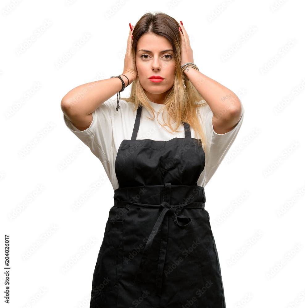 Shop owner woman wearing apron covering ears ignoring annoying loud noise, plugs ears to avoid hearing sound. Noisy music is a problem. Shop owner woman wearing apron covering ears ignoring annoying loud noise, plugs ears to avoid hearing sound. Noisy music is a problem.