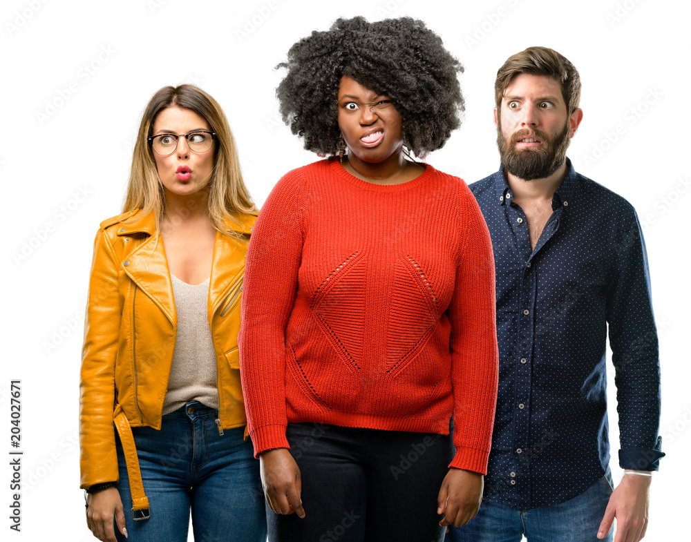 Group of three young men and women making funny face fooling Group of three young men and women making funny face fooling