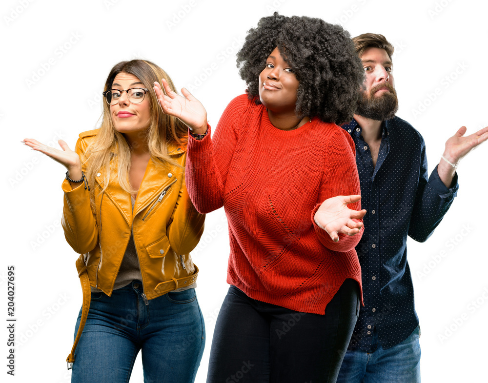 Group of three young men and women doubt expression, confuse and wonder concept, uncertain future Group of three young men and women doubt expression, confuse and wonder concept, uncertain future