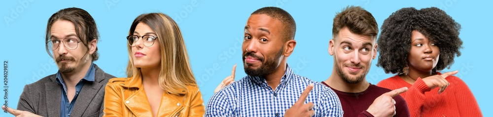 Obraz premium Group of mixed people, women and men pointing away side with finger