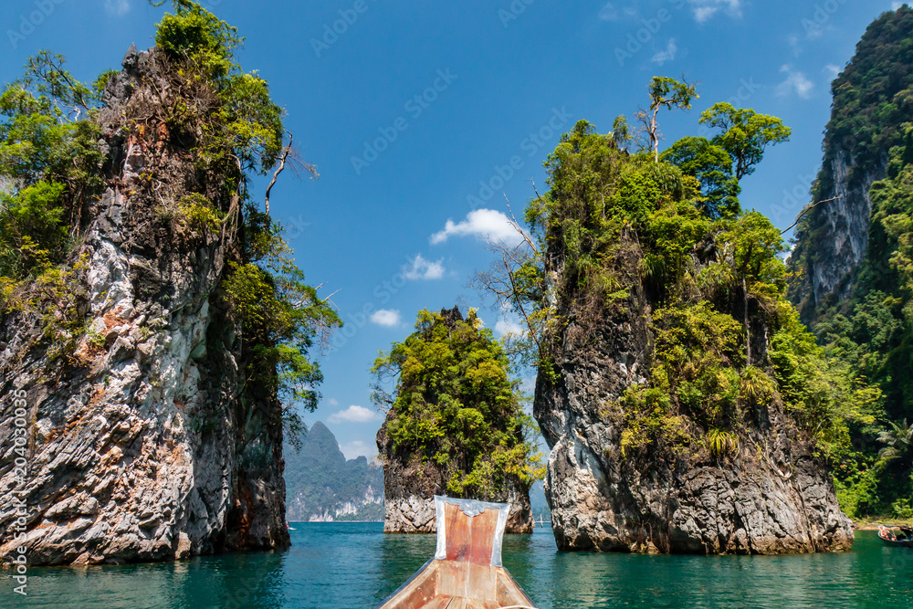 Towering cliffs and lush green jungle on a beautiful tropical lake in Thailand