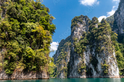 Towering cliffs and lush green jungle on a beautiful tropical lake in Thailand