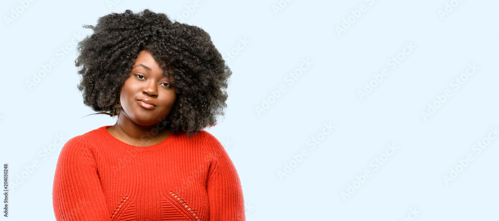 Obraz premium Beautiful african woman confident and happy with a big natural smile laughing, blue background