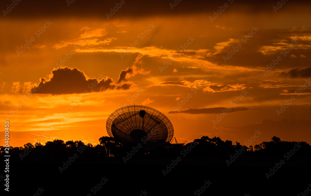 Telescopic Dish during against a red fiery sunset sky.
