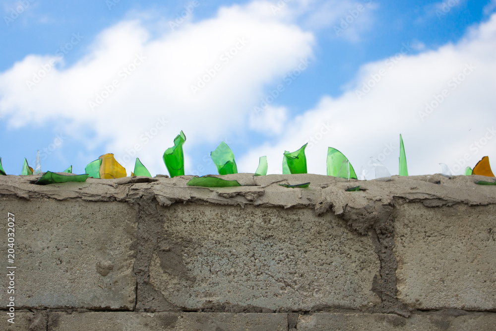 Broken glass on the top of the fence so that it can not be climbed