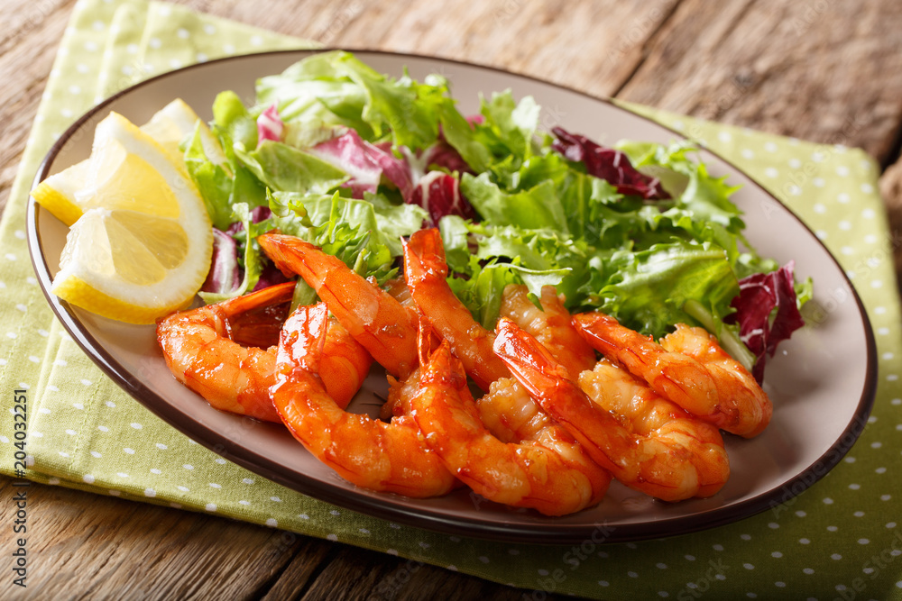 Caramelized prawns with honey and soy sauce and fresh lettuce close-up on a plate. horizontal Caramelized prawns with honey and soy sauce and fresh lettuce close-up on a plate. horizontal