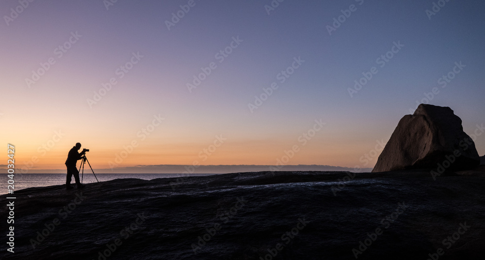 Photographer at dawn at the Bow Hole, Tasmania