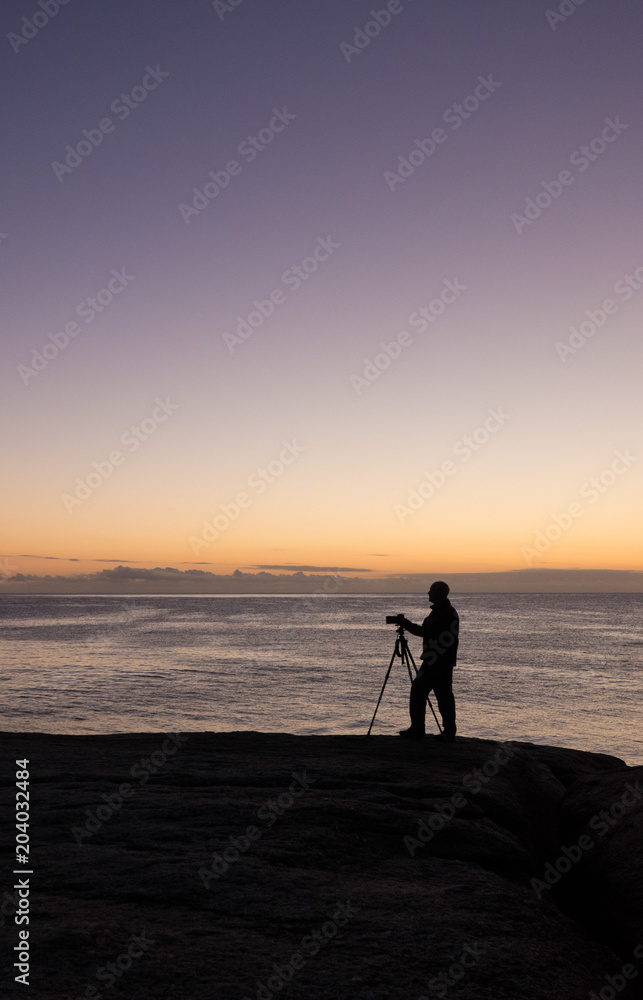 Photographer at dawn at the Bow Hole, Tasmania